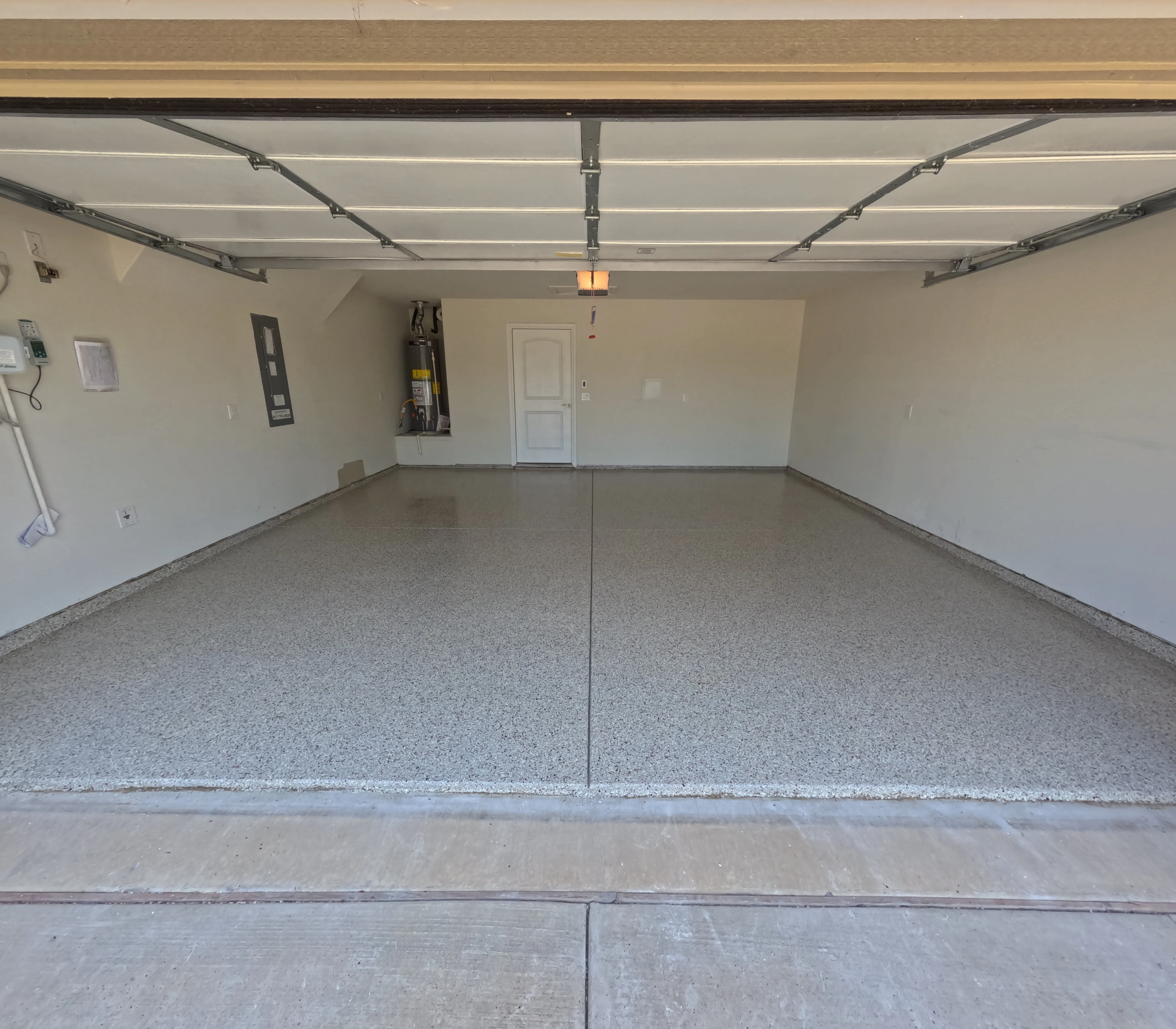 Finished epoxy garage floor with gray speckled coating and clean center seam